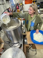 Deb pouring soy wax into the wax melter in her studio