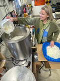 Deb pouring soy wax into the wax melter in her studio