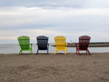 4 colored chairs facing the ocean