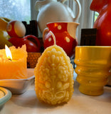 beeswax candle burning and unlit beeswax carved egg candle