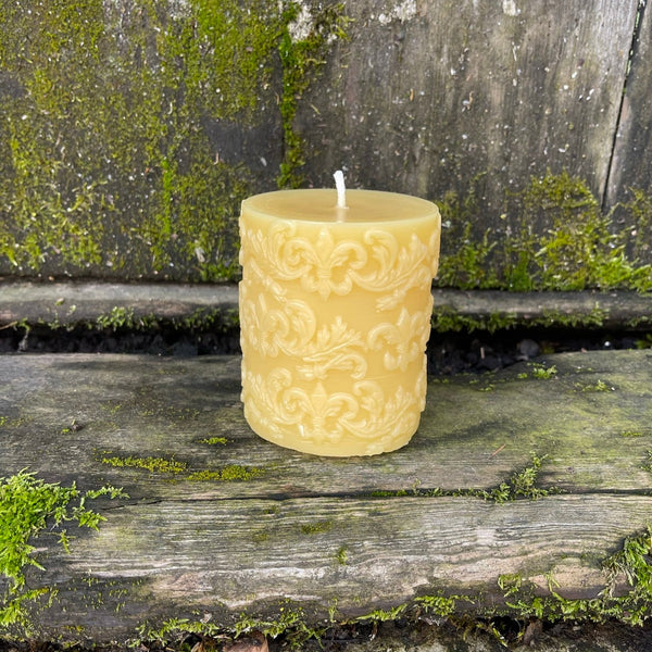 molded beeswax candle with a fleur di lis pattern