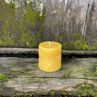 beeswax cylinder candle with bees on it