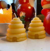 close up of 2 beeswax candles shaped as skeps