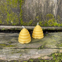 two beeswax candles shaped like bee hives (skeps)