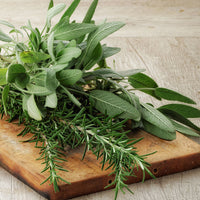 fresh rosemary and sage on a cutting board